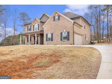 Inviting two-story brick home featuring dark shutters and a spacious front yard with an attached two-car garage at 224 Jester Ct, Mcdonough, GA 30252