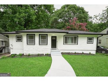 Charming home featuring a manicured lawn, a fresh paint job, and a welcoming walkway at 2508 Sylvan Rd, East Point, GA 30344