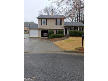 Two-story home with a well-kept front yard and two car garage at 6120 Raleigh Oaks Ct, Lithonia, GA 30058