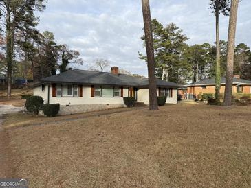 Charming single story home with a white painted brick exterior and lovely dark shutters at 2577 Headland Dr, East Point, GA 30344