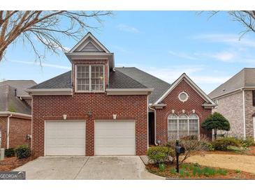 Charming brick home with a two-car garage and well-maintained front yard at 6275 Glen Oaks Ln, Atlanta, GA 30328