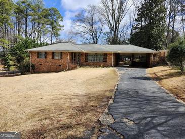 Charming one-story brick home with covered parking and a spacious front yard at 5535 Beaver Sw Dr, Mableton, GA 30126