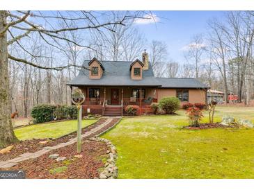 Charming two-story home with a beautifully landscaped front yard and inviting front porch at 630 Stoney Point Rd, Bowdon, GA 30108