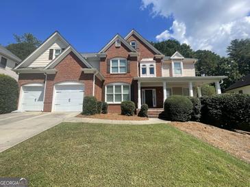 Beautiful brick home with a well-manicured lawn and a two-car garage at 4043 Windgrove Xing, Suwanee, GA 30024