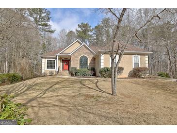 Charming home featuring a stone facade, manicured landscaping, and a welcoming red front door at 40 High St, Sharpsburg, GA 30277