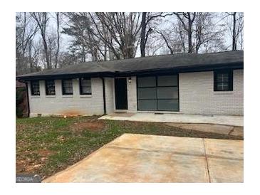 Charming single-story home with a brick facade, dark window trim, concrete driveway, and cozy curb appeal at 3490 Primrose Pl, Decatur, GA 30032