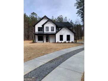 Stunning two-story modern farmhouse featuring white siding, black accents, and well-maintained front yard at 3785 Pilgrim Mill Rd, Cumming, GA 30041