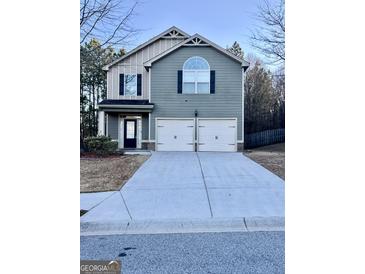 Two-story home with a two-car garage and a well-maintained front lawn at 7522 Springbox Dr, Fairburn, GA 30213
