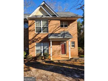 Traditional brick townhouse with a covered front porch and well-maintained landscaping at 3874 Austin Park Ne Ln, Decatur, GA 30032