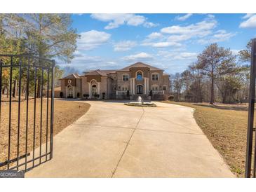 Elegant, multi-story home featuring a circular driveway with fountain, manicured landscaping, and a grand entrance at 1408 Hemphill Rd, Stockbridge, GA 30281