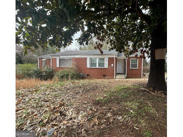Traditional-style brick home featuring white trimmed windows and partial front yard view at 1721 Lisbon Sw Dr, Atlanta, GA 30310