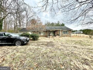 A single story home featuring a stone facade, covered porch, and a neatly landscaped front yard at 3210 Rogers Rd, Mcdonough, GA 30252