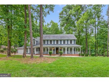 Charming two-story home with a inviting front porch and lush landscaping at 105 Oak Leaf Ct, Fayetteville, GA 30214