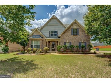 Charming two-story brick home featuring lush landscaping and a well-manicured lawn at 1186 Diamond Xing, Mcdonough, GA 30252