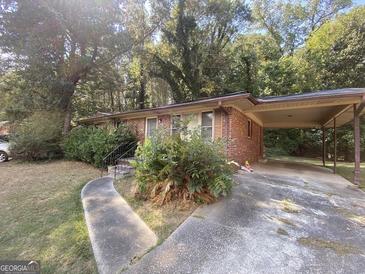 Charming single-story brick home with a covered carport and established landscaping at 439 Oakside Sw Dr, Atlanta, GA 30331