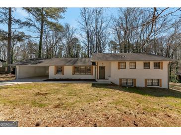 Charming brick home featuring a spacious carport and complementary shutters at 2598 Lake Shore, College Park, GA 30337