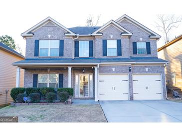 Charming two-story brick home with a well-manicured lawn, a two car garage, and classic shutters at 7625 Bowhead Ct, Fairburn, GA 30213