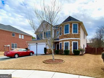 Charming two-story home featuring a turret, stone accents, and a well-maintained lawn at 2618 Hooch Ct, Duluth, GA 30097