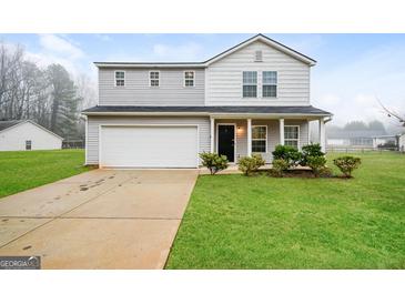 Charming two-story home with a well-manicured lawn and an attached two-car garage at 415 Arthurs Ln, Covington, GA 30016