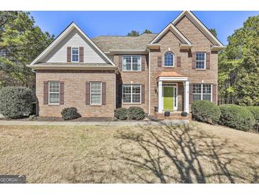 Beautiful brick two-story home featuring symmetrical design, a gabled roof, and manicured front yard at 44 Willow Leaf Way, Sharpsburg, GA 30277