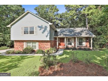 Charming two-story home with a combination of light blue siding and red brick exterior, complemented by a well-manicured front yard at 201 Lanyard Loop, Peachtree City, GA 30269