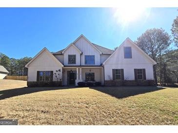 An inviting home showcasing a combination of stone, siding, and shuttered windows at 34 Brittany Way, Palmetto, GA 30268