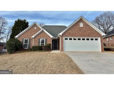 Charming single-story brick home with a well-manicured lawn and attached two-car garage at 410 Oakpark Ter, Mcdonough, GA 30253