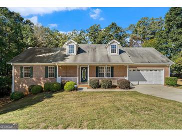 Charming brick home featuring an attached garage and inviting front porch at 225 Chinns Way, Hampton, GA 30228