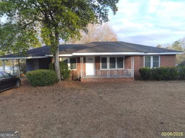 Charming single-story brick home with well-maintained lawn and mature tree in a quiet residential neighborhood at 106 Flippen Rd, Stockbridge, GA 30281