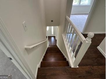 View of wood staircase with white railing and freshly painted walls leading to front door of home at 281 Timber Laurel Ln, Lawrenceville, GA 30043