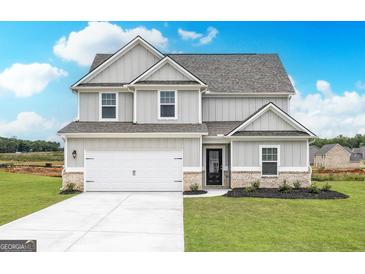 Charming two-story home featuring a brick-accented facade, a two-car garage, and a well-maintained lawn at 1048 Claas Way, Locust Grove, GA 30248