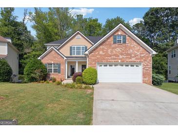 Charming two-story brick home with a well-manicured lawn and a two-car garage at 260 Millbrook Village Dr, Tyrone, GA 30290