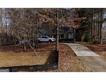 Suburban home with long driveway and white pickup truck in the front yard at 24 Picketts Mill Pl, Acworth, GA 30101