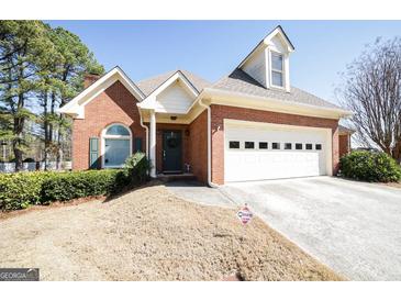 Charming brick home with a well-manicured lawn and two-car garage at 1800 Stockton Walk Ln, Snellville, GA 30078
