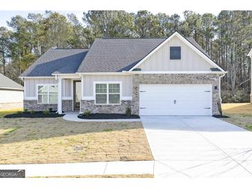 Charming single-story home with brick accents, gray siding, and a two-car garage at 3372 Arabian Farm Ln, Dacula, GA 30019