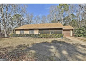 Ranch style home with a screened in porch, driveway, and partial view of the yard at 439 Elder St, Fairburn, GA 30213