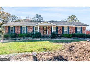 Charming brick home with manicured landscaping, shutters, and inviting front porch at 434 Lees Lake Rd, Fayetteville, GA 30214