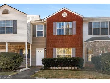 Charming townhouse featuring a red brick facade and well-maintained front yard landscaping at 1235 Labonte Pkwy, Mcdonough, GA 30253