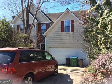Two story home with attached two car garage, mature landscaping, and a driveway with an automobile at 2054 Gwinn Dr, Norcross, GA 30071