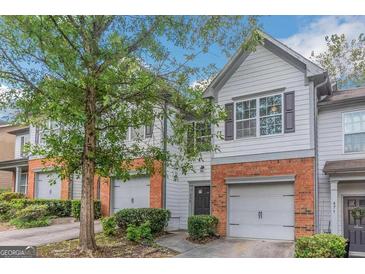 Charming townhouse featuring a brick facade, single-car garage, and well-maintained landscaping at 473 Tufton Se Trl, Atlanta, GA 30354