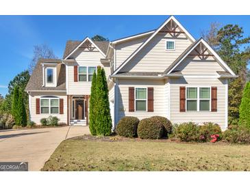 Charming two-story home with tan siding, brown shutters, manicured landscaping, and a welcoming entrance at 109 Faversham Dr, Mcdonough, GA 30252