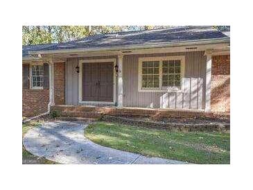 Welcoming home entrance with a double front door, brick accents, and mature landscaping at 250 Devilla Trce, Fayetteville, GA 30214