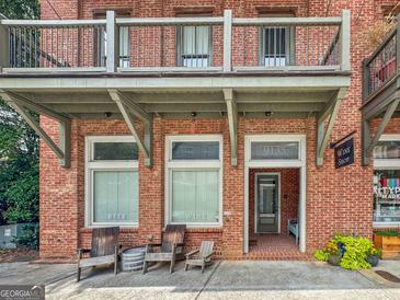 Charming two-story brick building featuring a wine shop, balcony, and outdoor seating at 9135 Selborne Ln, Chattahoochee Hills, GA 30268