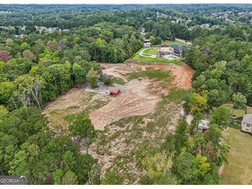 Expansive aerial view of wooded acreage, showcasing potential building sites and nearby luxury homes at 3630 Jim Moore Rd, Dacula, GA 30019