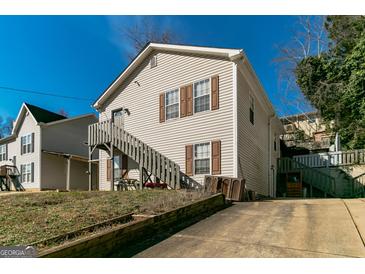 Two-story home with light siding, brown shutters, and a wooden staircase leading to the entrance at 5365 Renault St, Cumming, GA 30041