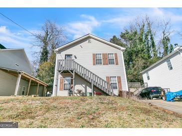 Two-story home featuring a front staircase, neutral siding, and classic window shutters at 5365 Renault St, Cumming, GA 30041