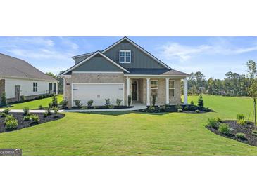 Charming single-Gathering home with a well-manicured lawn, attached garage, and stone and siding exterior at 588 Parnassus Road, Locust Grove, GA 30248