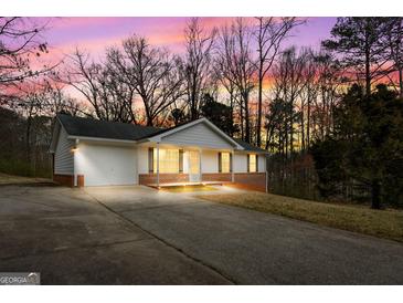 Charming ranch-style home with brick accents, an attached garage, a wide driveway, and well-maintained landscaping at 4601 Highway 81 E, Mcdonough, GA 30252