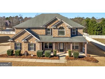 Beautiful two-story brick home featuring a well-manicured lawn and welcoming front porch at 508 Fall Creek Ct, Mcdonough, GA 30253