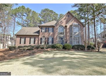 Stunning brick home featuring a well-manicured lawn, mature trees, and classic architectural details at 245 Highview Trce, Fayetteville, GA 30215